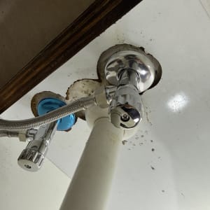 צנרת מתחת לכיור עם ברזים וחיבורים