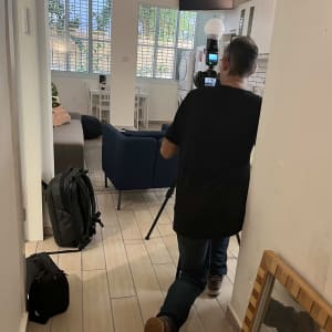 צלם עם מצלמה על חצובה בתוך חדר מגורים