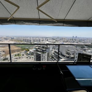 מרפסת עם נוף עירוני וסוכך מעל
