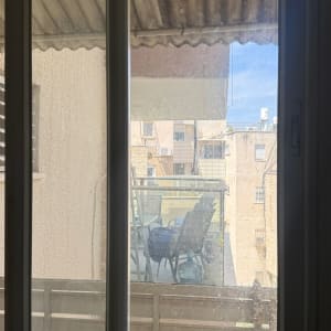 חלון עם נוף למרפסת ובניינים