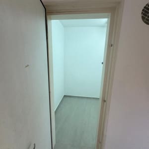 חדר ריק עם קירות צבועים בלבן ודלת פתוחה