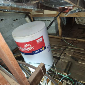 דוד שמש לבן עם צינורות וחיבורים בעליית גג