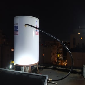 דוד שמש על גג בלילה עם צינור מחובר