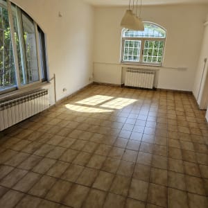 חדר ריק עם רצפת אריחים נקייה וחלונות גדולים