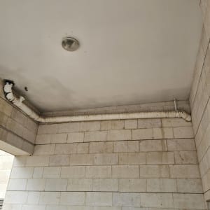 תקרה עם צינור מבודד ומנורה עגולה