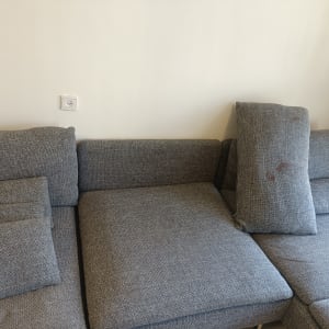 ספה אפורה עם כתמים על כרית אחת