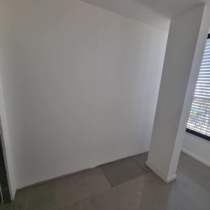 קיר גבס לבן עם חלון ותריסים