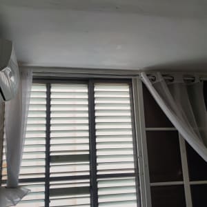 חלון עם תריסים וילון לבן תלוי