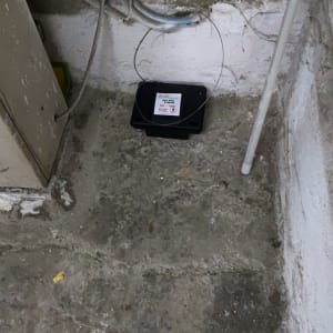 תחנת פיתיון להדברת מזיקים בפינה על רצפת בטון