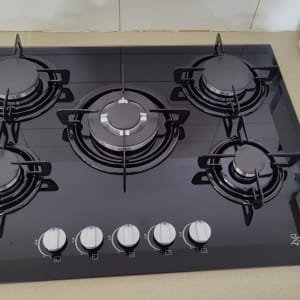 כיריים גז שחורות עם חמישה מבערים וכפתורי שליטה