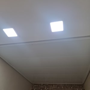 תקרת גבס עם תאורה מרובעת וקיר אריחים