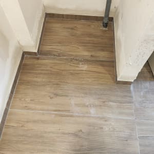 רצפת עץ חדשה עם צינור חשוף בפינה