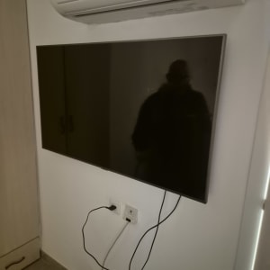 טלוויזיה מותקנת על הקיר עם חוטים מחוברים