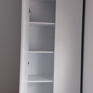 ארון לבן עם דלת פתוחה ומדפים פנימיים