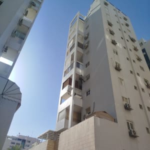 אדם עובד על בניין גבוה, כנראה בתחום הסרת יונים