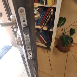 מנעול דלת עם ידית כסופה וספרים ברקע