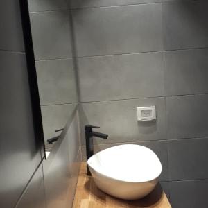 כיור לבן על משטח עץ בחדר אמבטיה