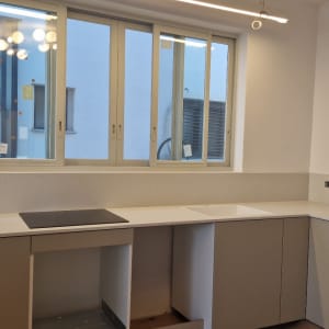 משטח שיש לבן במטבח מודרני עם כיור וכיריים