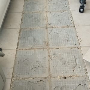 רצפה עם אריחים שבורים וכלי עבודה חשמלי