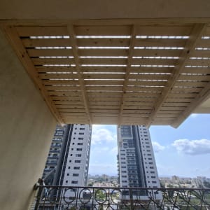 פרגולה מעץ על מרפסת עם נוף לעיר