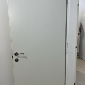 דלת לבנה עם ידית מתכת כסופה