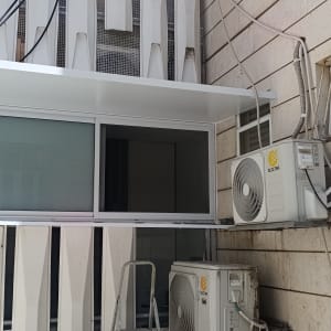 מרפסת אלומיניום עם מזגנים על קיר חיצוני