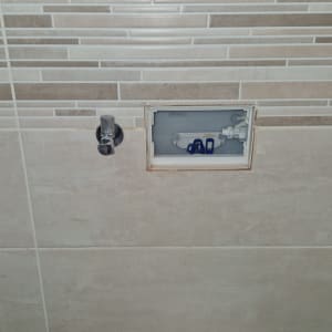 תמונה של אסלה עם חיבורי צנרת בקיר