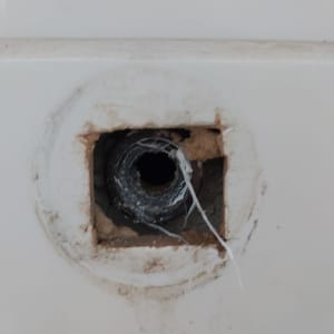 צינור מים חשוף בקיר עם חוטים לבנים