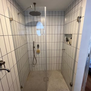 מקלחת עם ראש גשם, קירות אריחים ומדף מוצרים