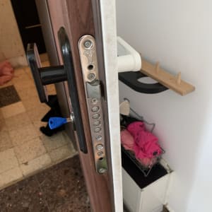 מנעול דלת עם מפתח כחול בדלת עץ פתוחה