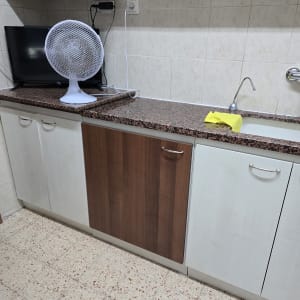 מטבח עם ארונות, כיור ומאוורר על השיש