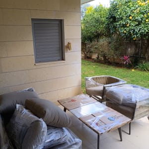 ריהוט ארוז במרפסת עם עצי פרי ברקע