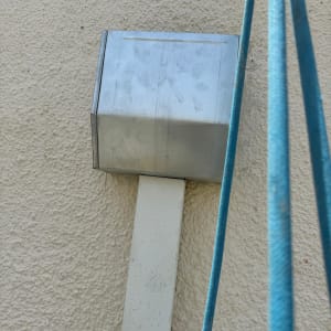 קופסת מתכת על קיר עם כבלים כחולים