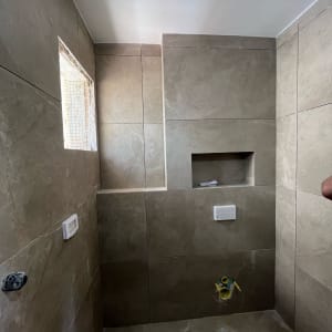 חדר אמבטיה עם אריחים חדשים וקיר בנייה