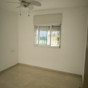 חדר ריק עם מאוורר תקרה וחלון