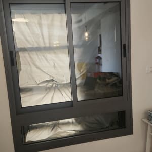 חלון עם ניילון לכיסוי במהלך שיפוץ