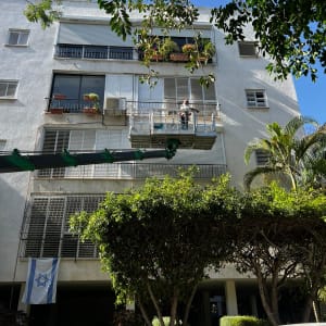 עבודה על תריסים בבניין מגורים עם פיגום חיצוני