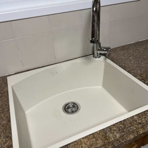 כיור מטבח עם ברז על משטח שיש חום