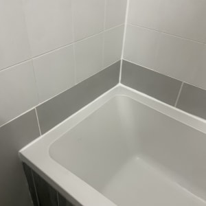 אמבטיה עם אריחי קרמיקה לבנים ואפורים