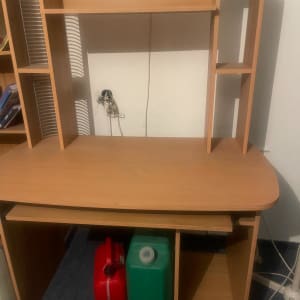 שולחן עץ עם מיכלים אדום וירוק מתחתיו