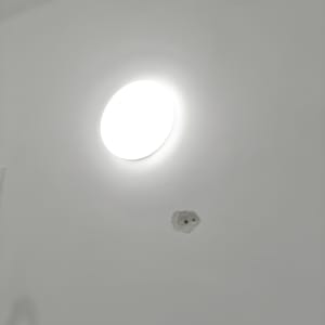 מנורה עגולה מוארת על תקרה לבנה