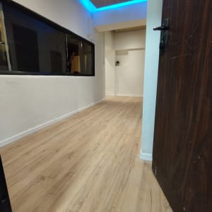 חדר עם רצפת פרקט עץ בהיר ותאורה כחולה