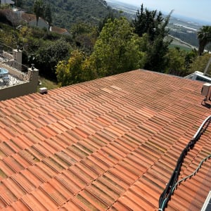 גג רעפים אדומים עם כבלים ומערכת סולארית