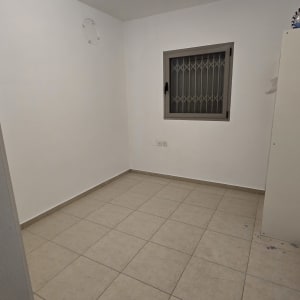 חדר ריק עם קירות צבועים ורצפת אריחים