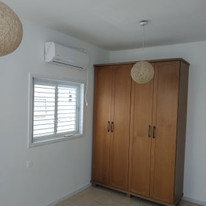 חדר עם ארון עץ ומזגן על הקיר