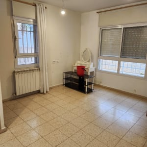 דלי אדום על שולחן בחדר ריק עם רצפה נקייה