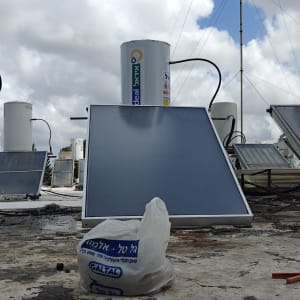 דוד שמש עם קולטים על גג תחת שמיים מעוננים