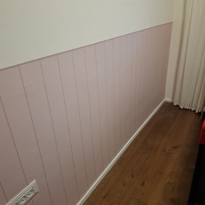 קיר עם טפט ורוד ורצפת עץ