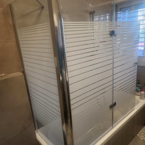 מקלחון זכוכית עם דלתות הזזה ופסים אופקיים