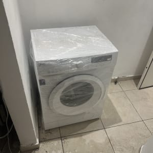 מכונת כביסה עטופה בניילון בחדר ריק